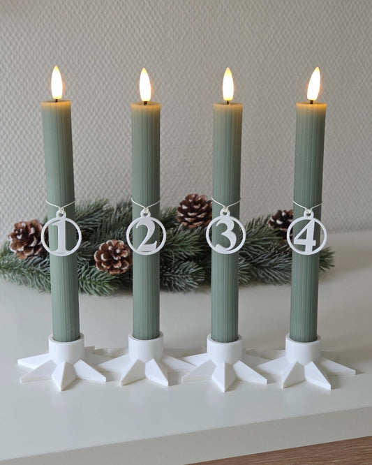 Adventstal 1–4 i hvid placeret på kalenderlys med stjerneformede lysestager – rolig adventsstemning med gran og levende lys i afbalancerede nuancer