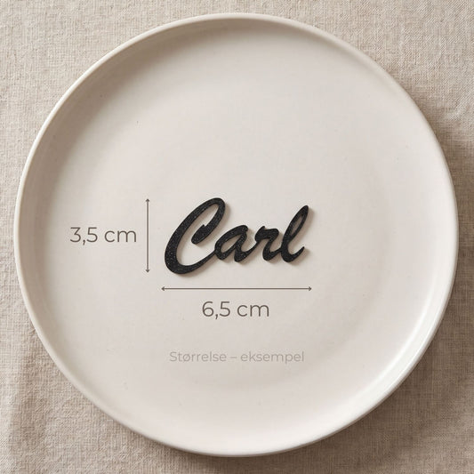 Bordkort med navn Carl i sort, liggende på tallerken