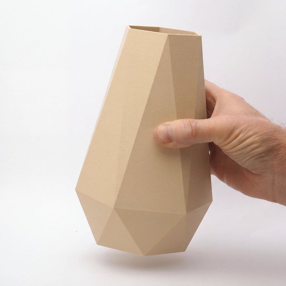 20 cm geometrisk beige vase i dansk design med facetteret form, holdt i hånden for at vise proportioner