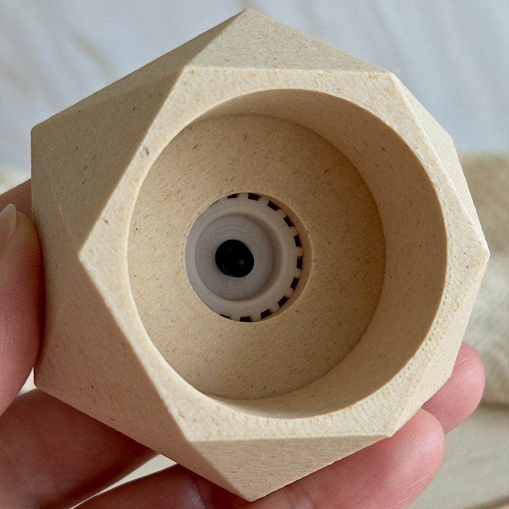 Underside af geometrisk, vendbar design lysestage i birk, der viser adgang til trykknap på LED-kronelys