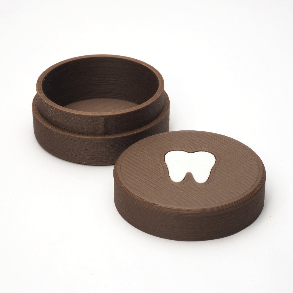 Lille tandfe æske til mælketænder med aftageligt låg, vist åbent med tandmotiv på låget ved siden af