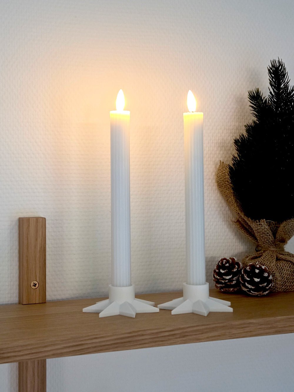 Hvis stjerneformet lysestage i dansk design med LED kronelys, vist som dekorativ julebelysning på hylde