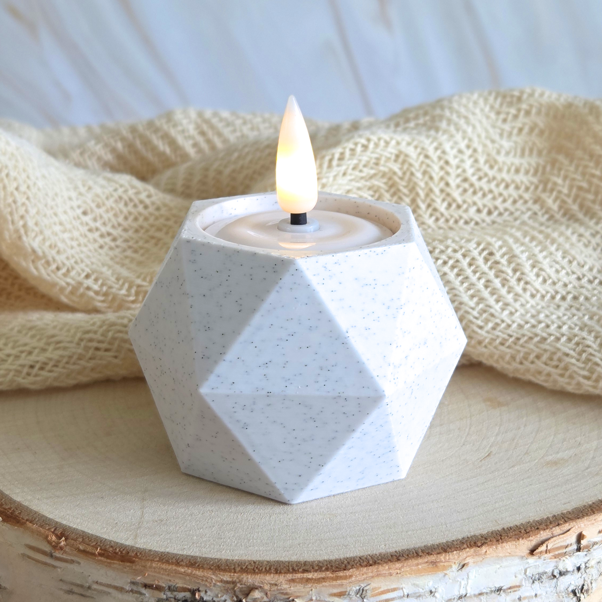 Lysestage i marmorlook med LED fyrfadslys – placeret med tekstil og lys træ