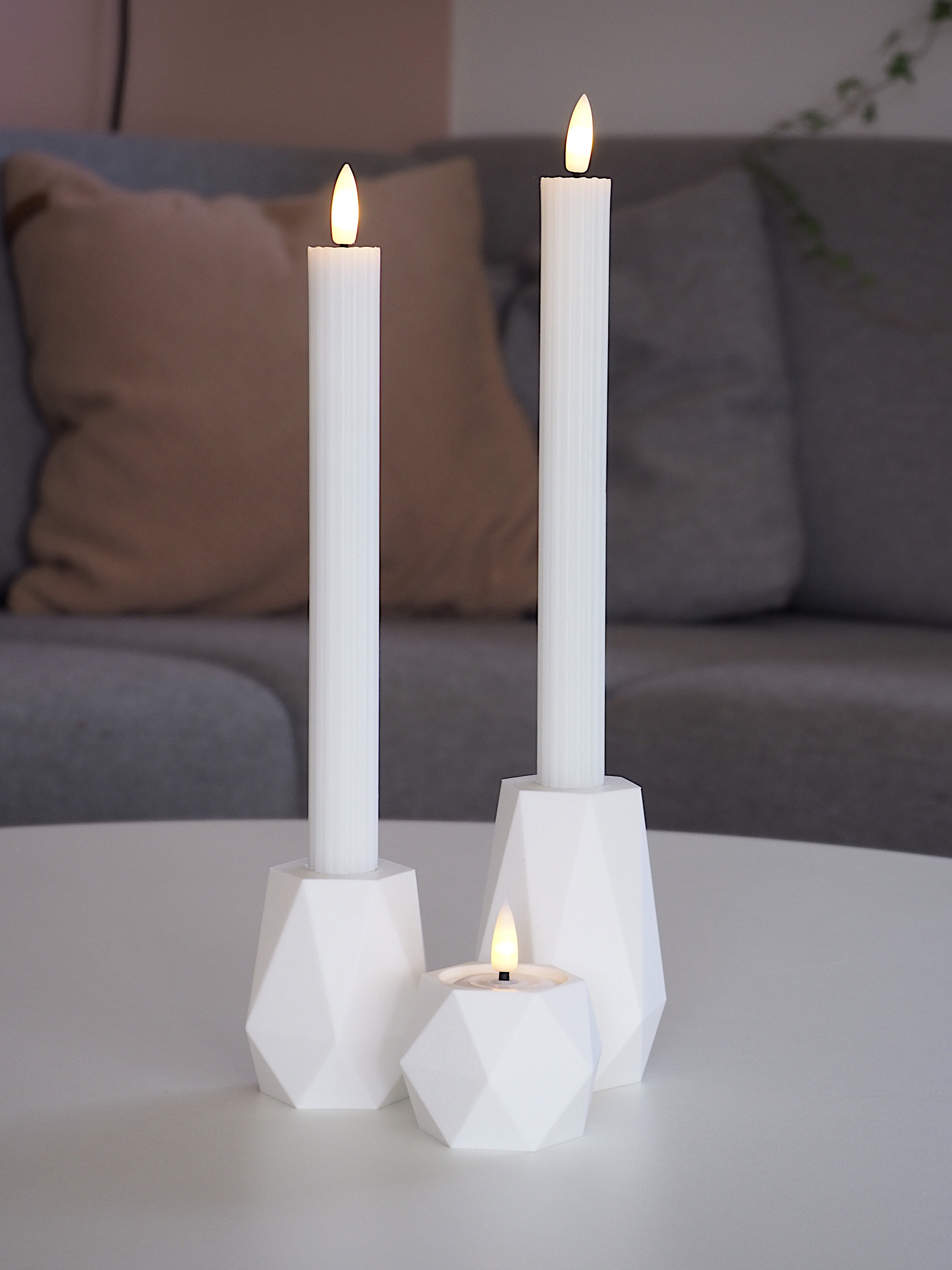 Hvid GEOMETRIC LED lysestagesæt på bord med rolige toner