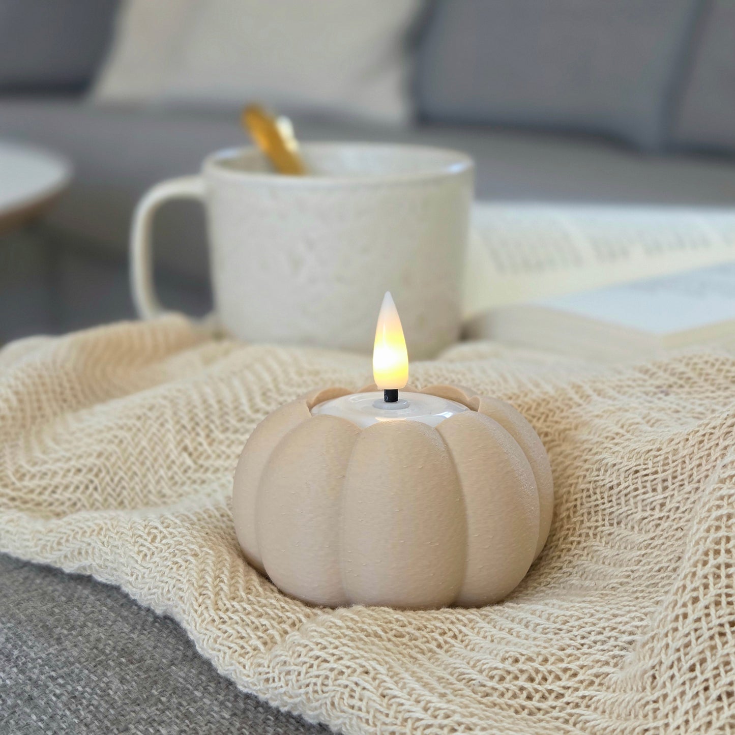 Græskar lysestage i beige – bæredygtig 3D print fra Hartli, med LED fyrfadslys stylet til efterårshygge med plaid og te