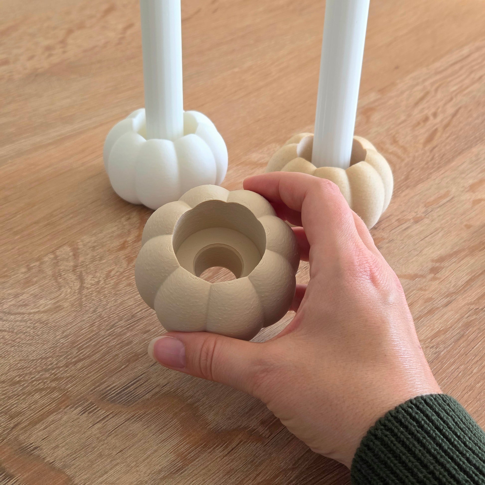 Græskar lysestage i beige – bæredygtig 3D print dekoration fra Hartli, kan bruges til både fyrfadslys og kronelys, vist i hånd