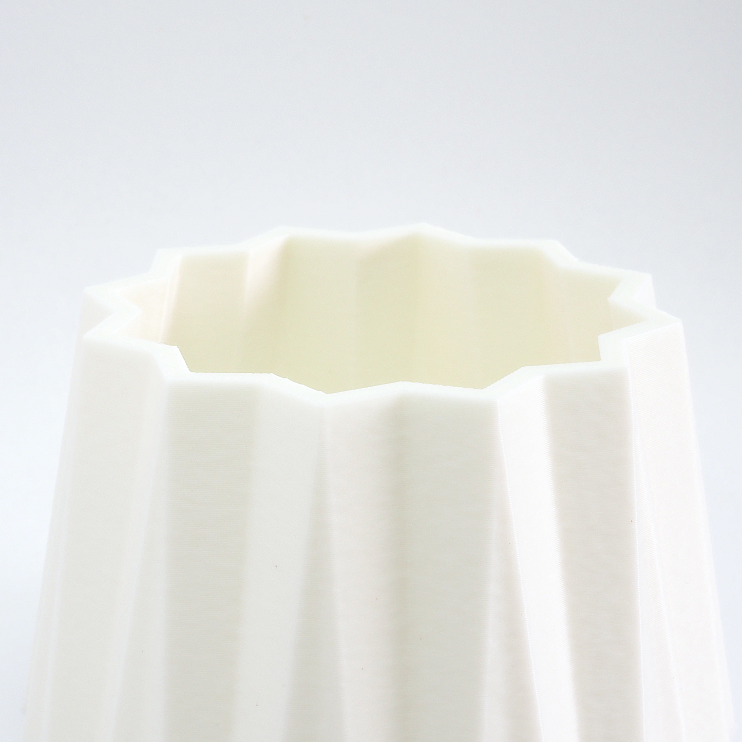 Close‑up af riller og struktur på hvid vase – detaljer og finish