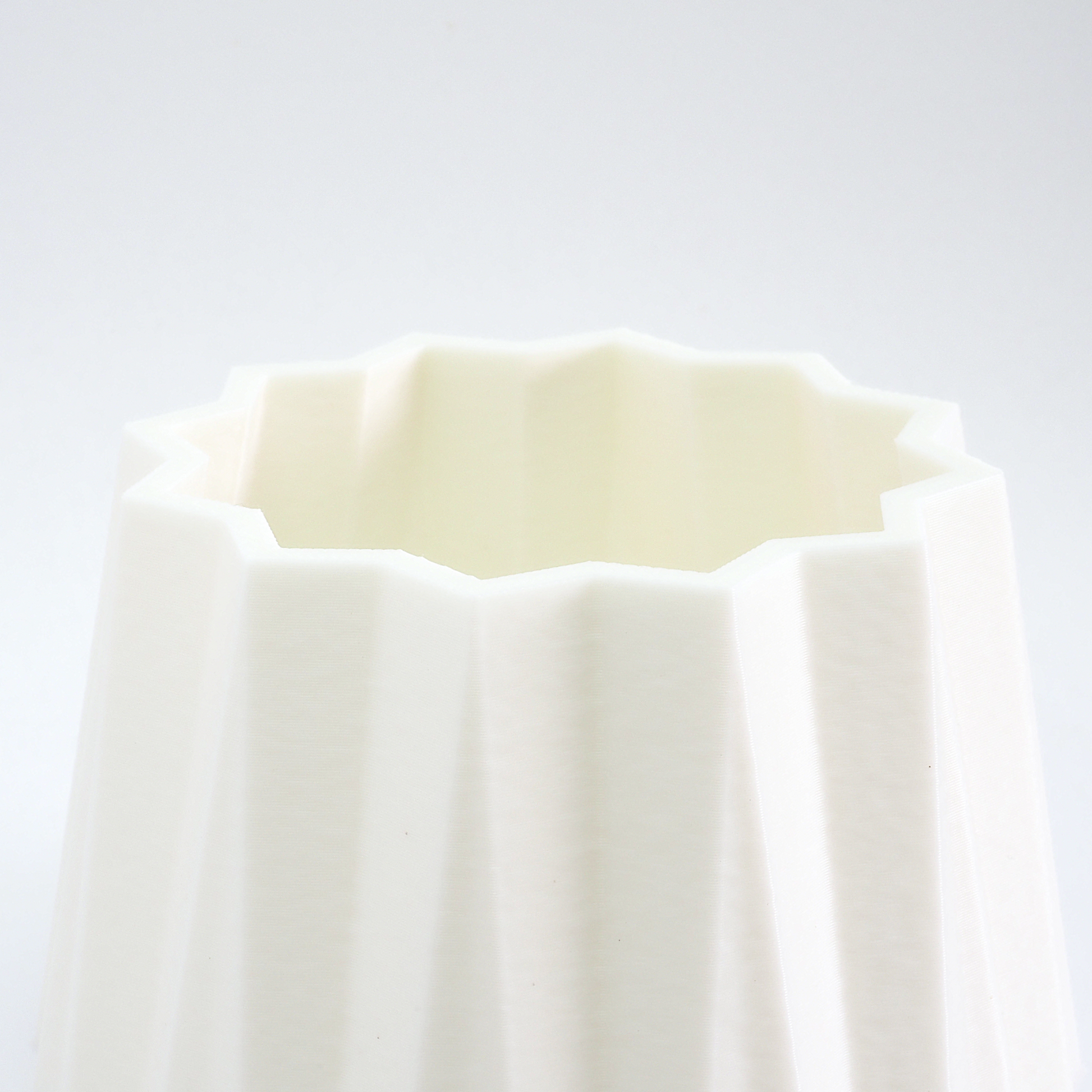 Close‑up af riller og struktur på hvid vase – detaljer og finish