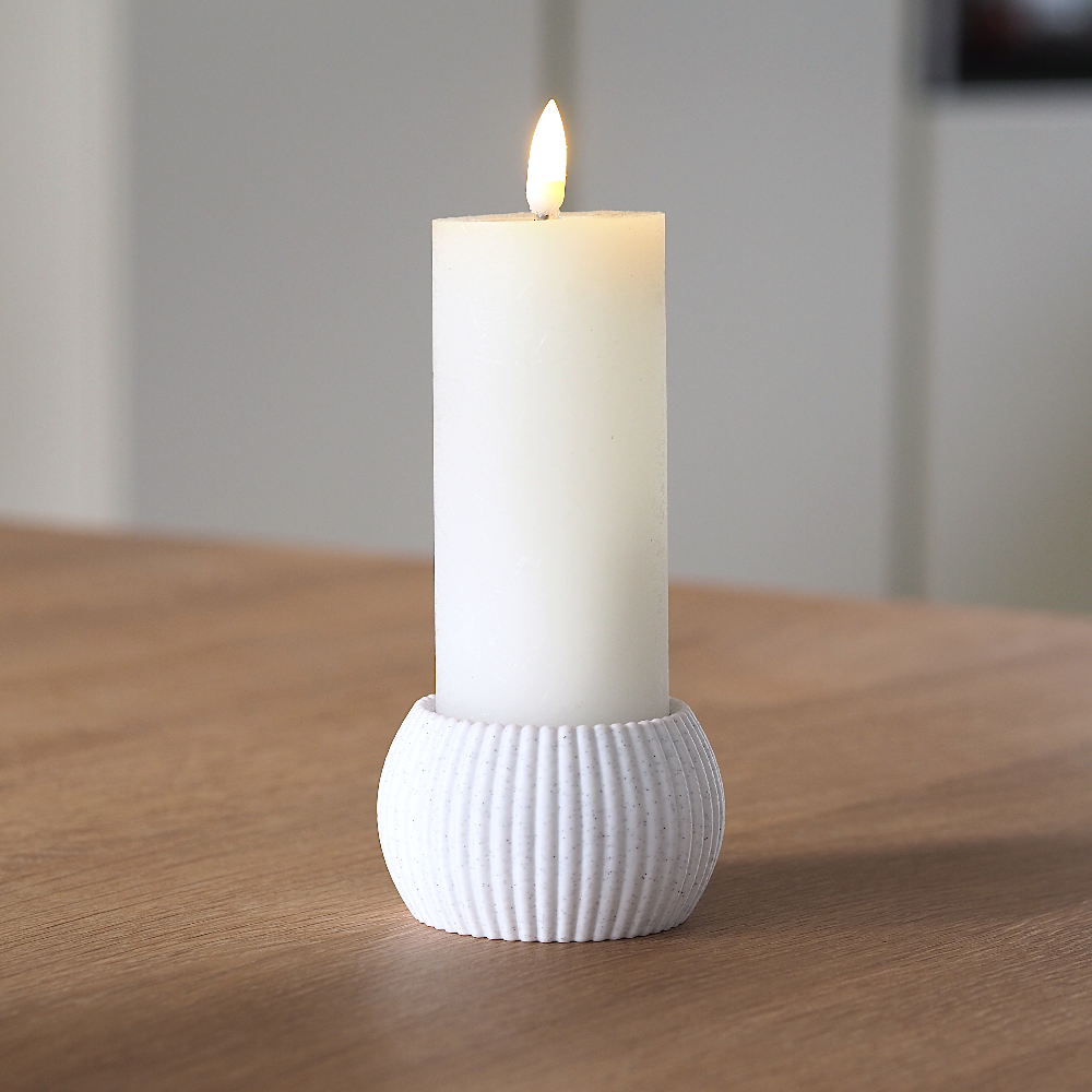 RIBB fyrfadsstage i marmorfarve brugt som holder til et tændt hvidt bloklys på træbord – enkelt og harmonisk dansk design produceret med omtanke og minimal spild.