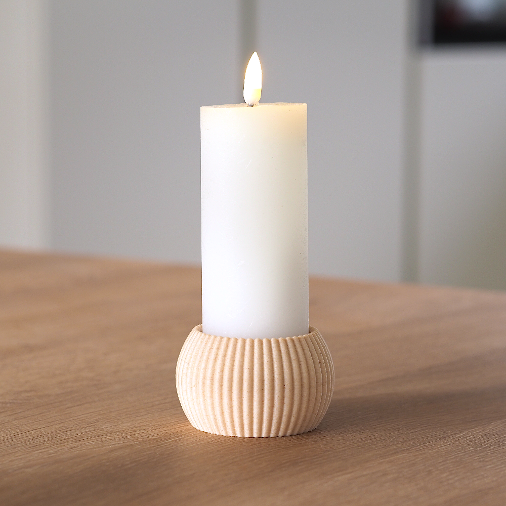 RIBB fyrfadsstage i birkefarve brugt som holder til et hvidt bloklys på træbord – enkelt og roligt dansk design produceret med omtanke og minimal spild.