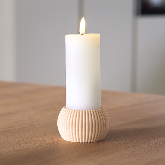 RIBB fyrfadsstage i birkefarve brugt som holder til et hvidt bloklys på træbord – enkelt og roligt dansk design produceret med omtanke og minimal spild.