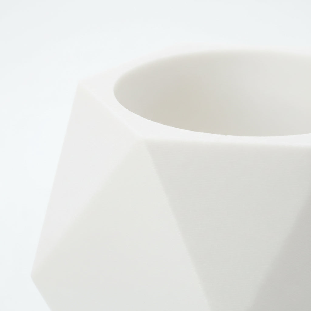 Nærbillede af åbningen til LED fyrfadslys på hvid lysestage – detaljeret visning af geometri og mat tekstur