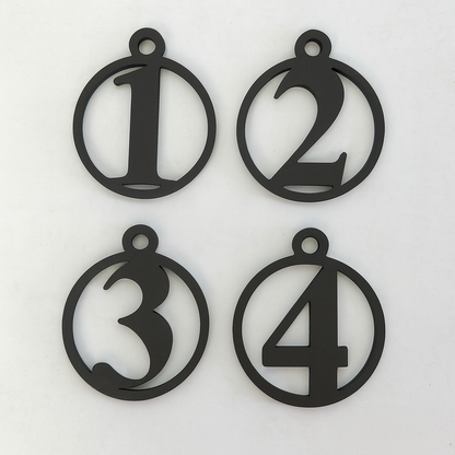 Fire adventstal i sort i enkelt cirkelform – stilren dekoration til kalenderlys og julegaver