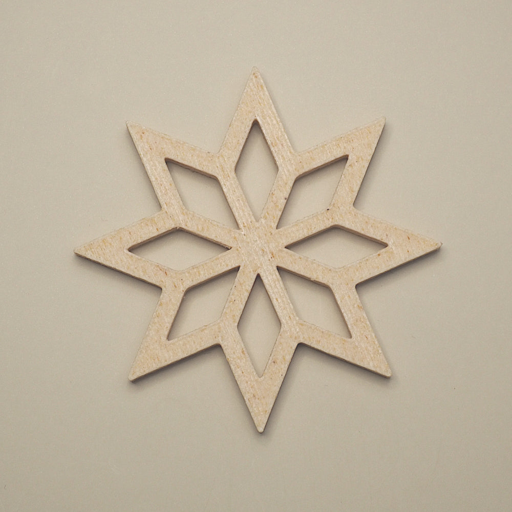 Birk farvet stjerneformet julepynt på lys baggrund – minimalistisk dekoration til juletræ, adventsgaver eller vinduer.