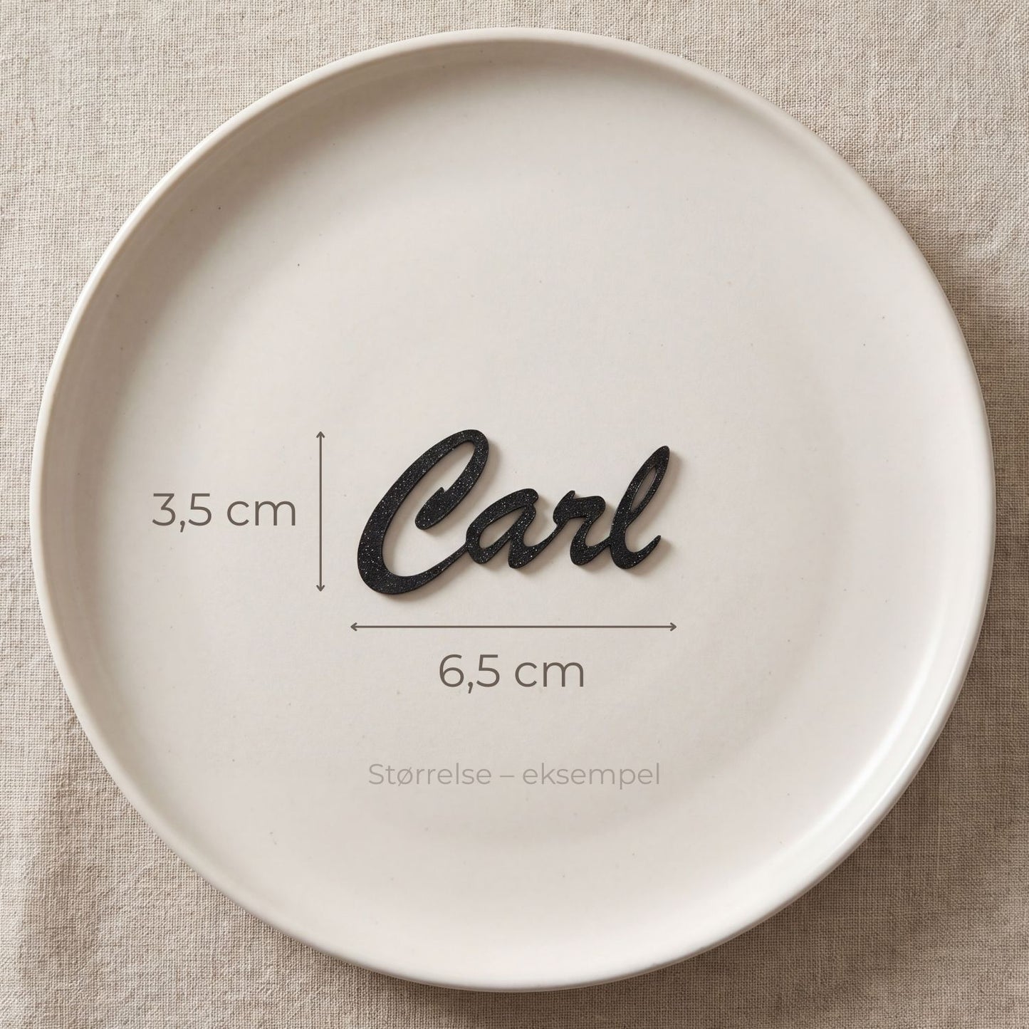 Bordkort med navn Carl i sort, liggende på tallerken