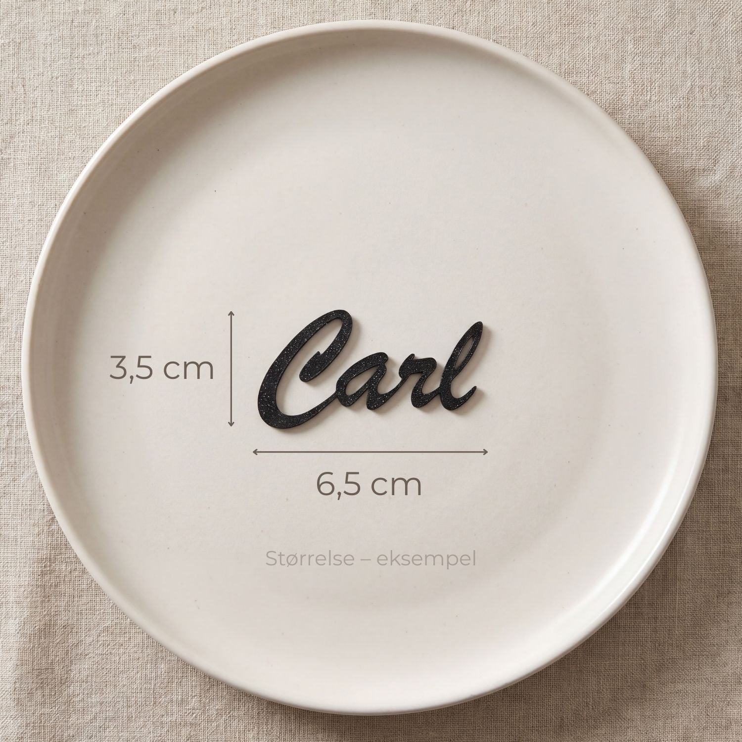 Bordkort med navn Carl i sort, liggende på tallerken