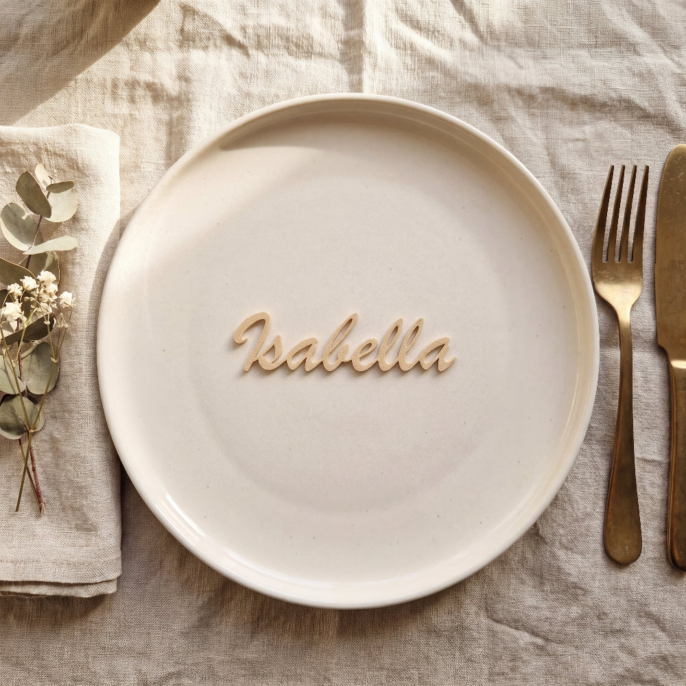 Personligt bordkort med navn Isabella i beige på tallerken i rolig borddækning