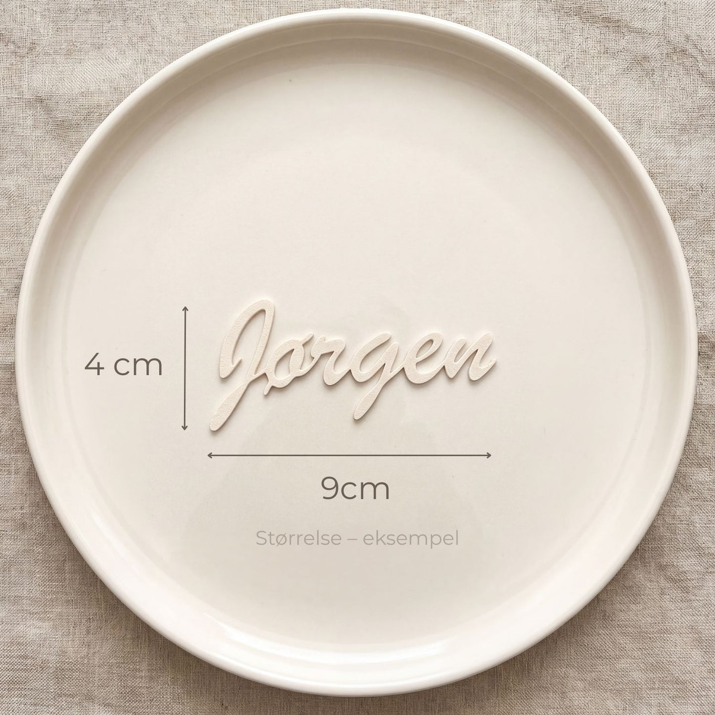 Bordkort med navn Jørgen i cream, liggende på tallerken