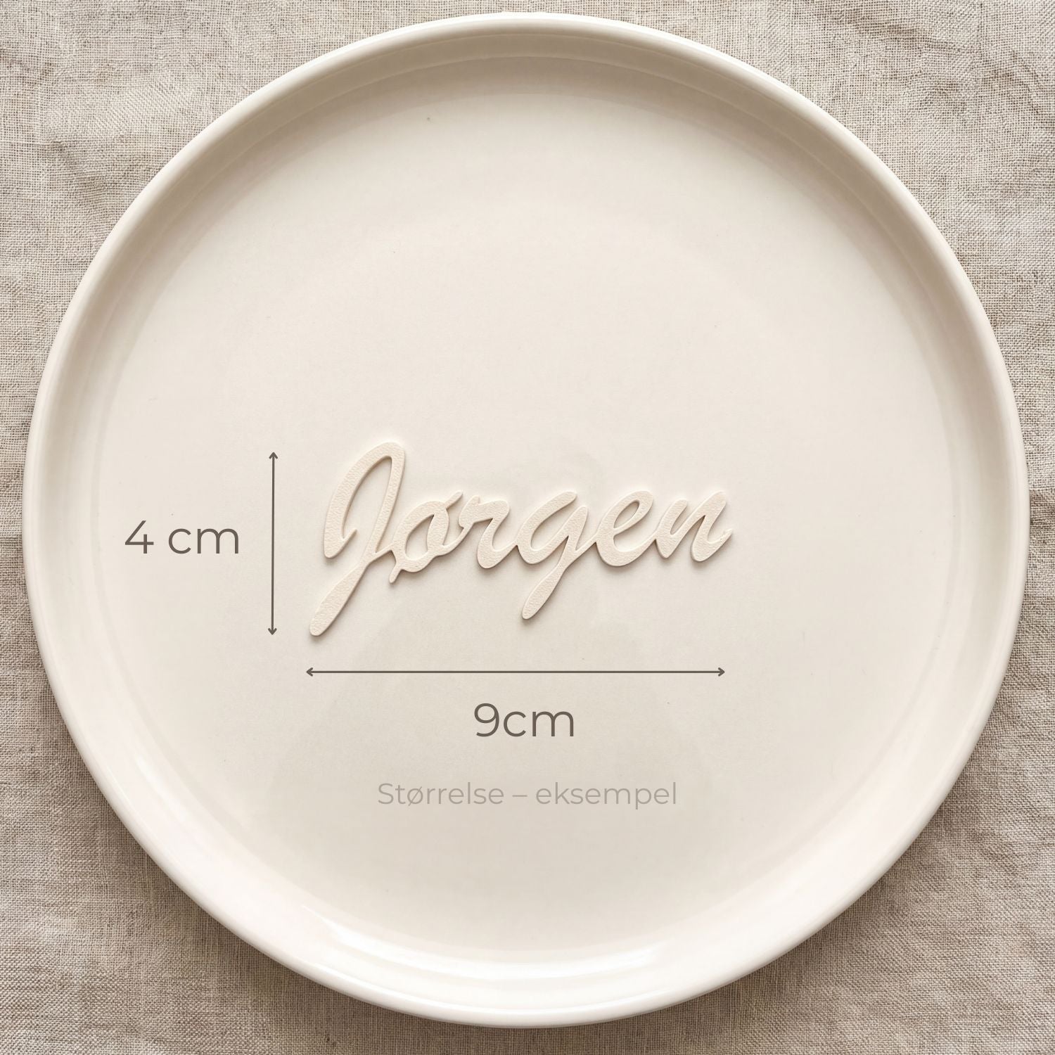 Bordkort med navn Jørgen i cream, liggende på tallerken
