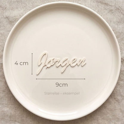 Bordkort med navn Jørgen i cream, liggende på tallerken