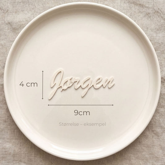 Bordkort med navn Jørgen i cream, liggende på tallerken