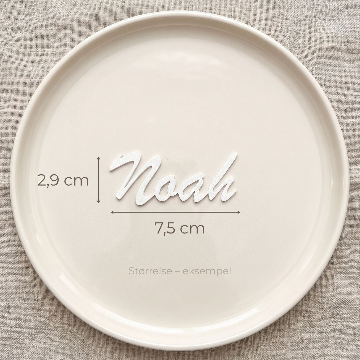 Bordkort med navn Noah i hvid, liggende på tallerken