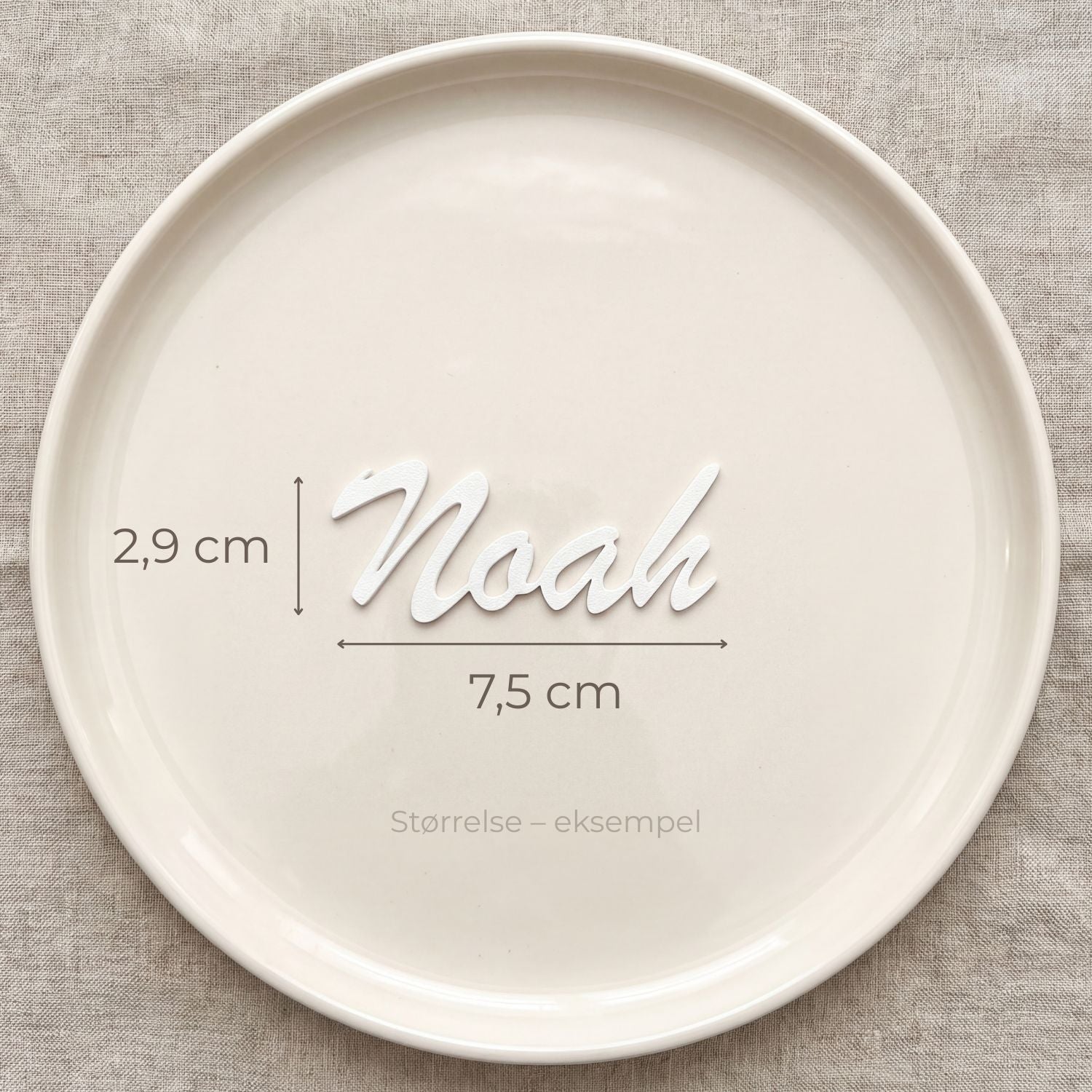 Bordkort med navn Noah i hvid, liggende på tallerken