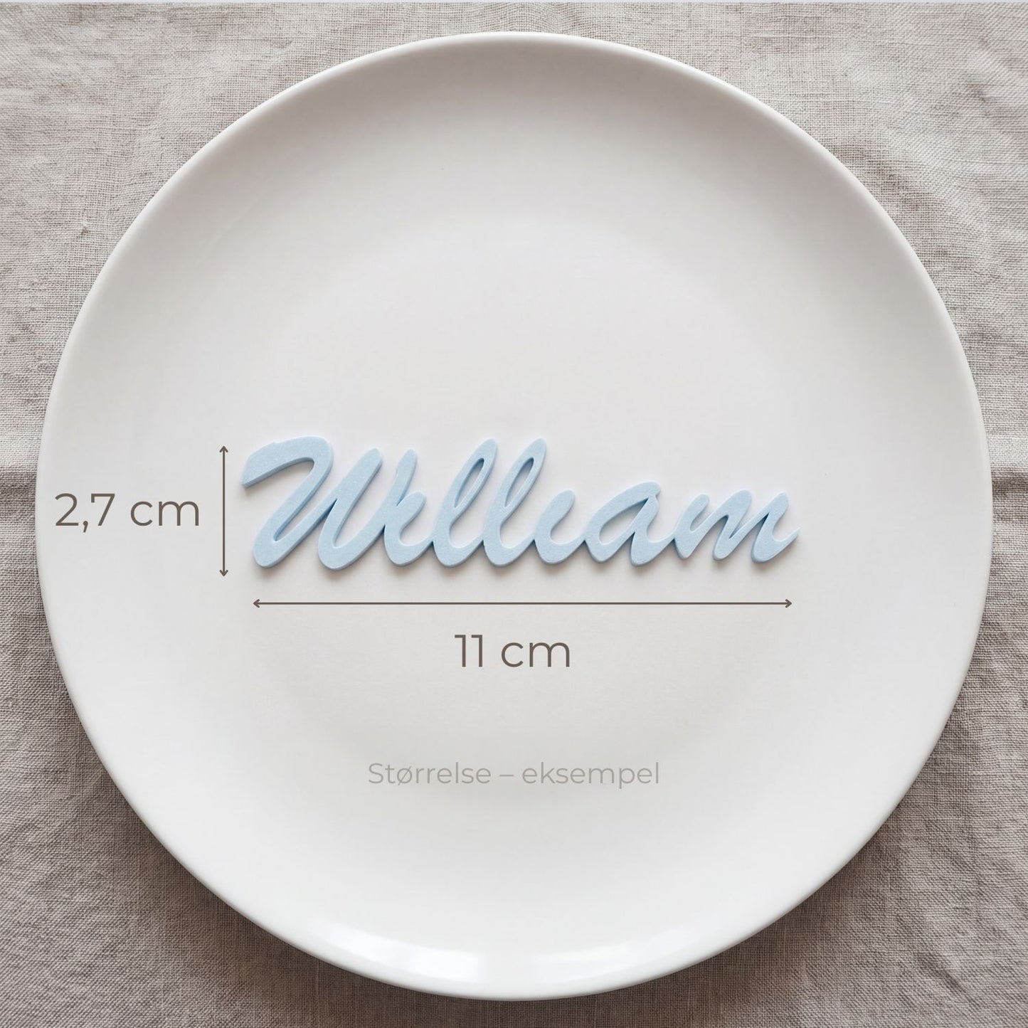 Bordkort med navn William i lyseblå, liggende på tallerken
