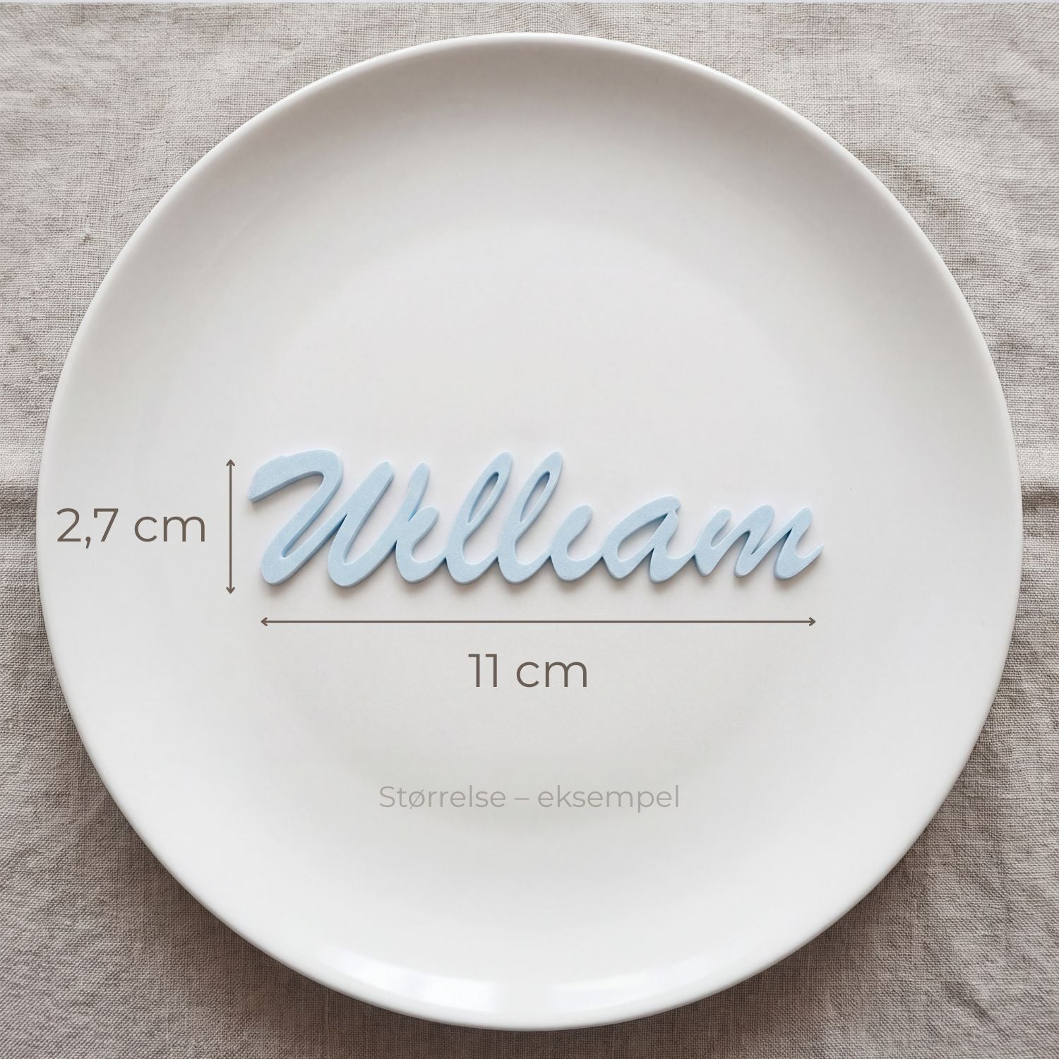 Bordkort med navn William i lyseblå, liggende på tallerken