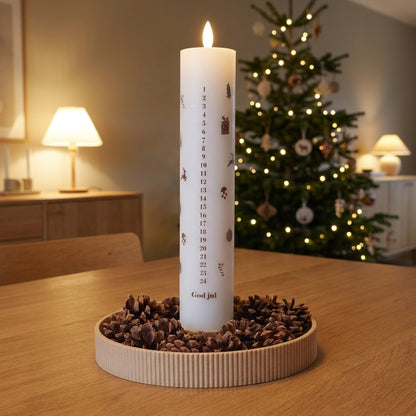 Dekorationsbakke til LED kalenderlys i dansk design med kogler på egetræsbord i et varmt julehjem.