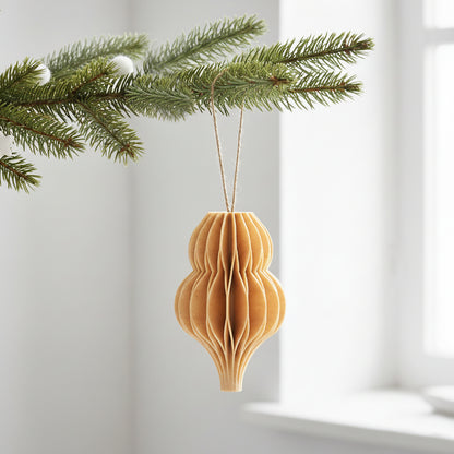 Birk farve honeycomb dråbe som julepynt på en grøn gren – enkel og varm dekoration til juletræ eller vintergrene.