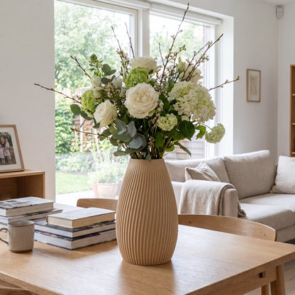 Flute vase i birk fra Hartli med friske blomster på spisebord i et lyst hjem.
