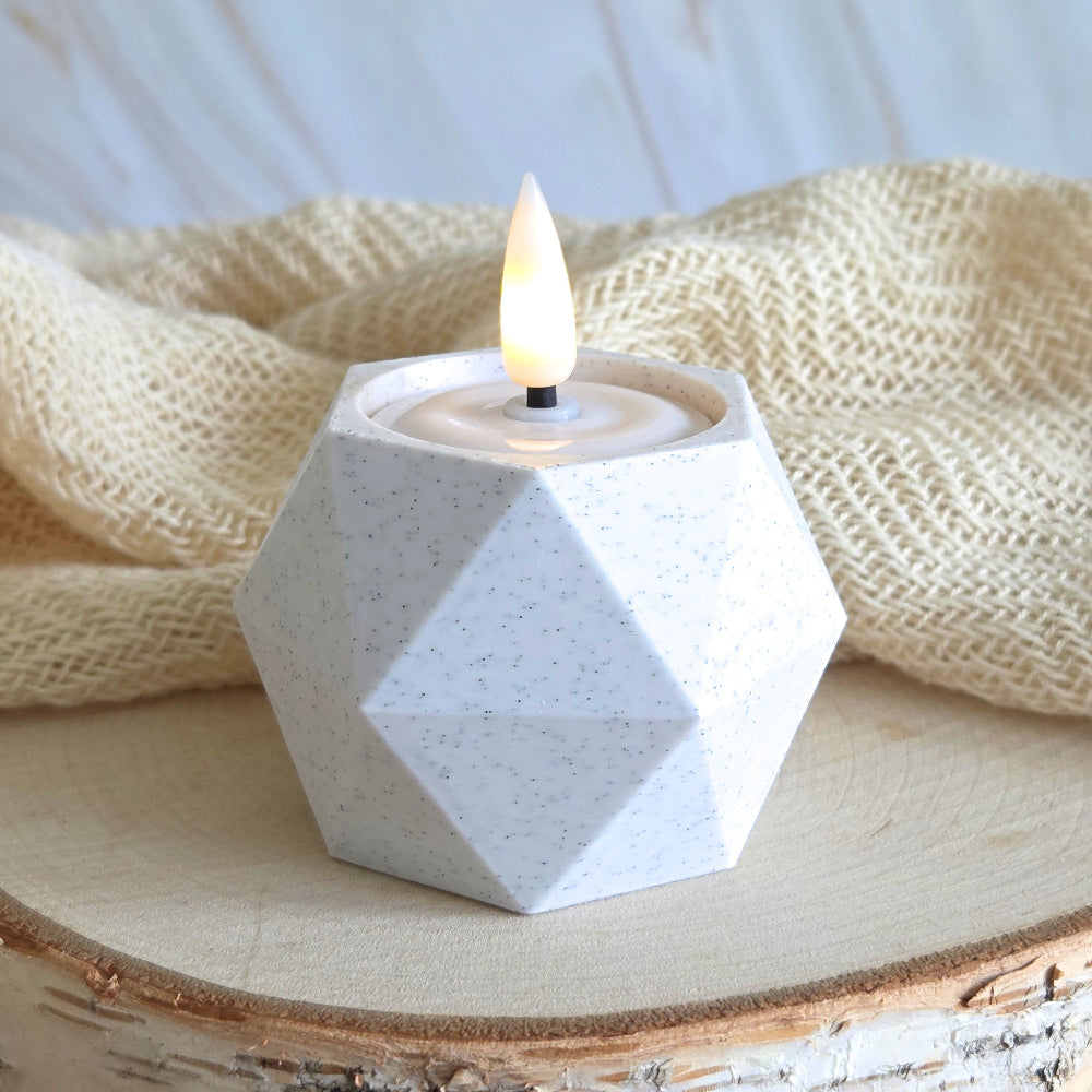 GEOMETRIC Lysestage i marmorlook med LED fyrfadslys – placeret med tekstil og lys træ