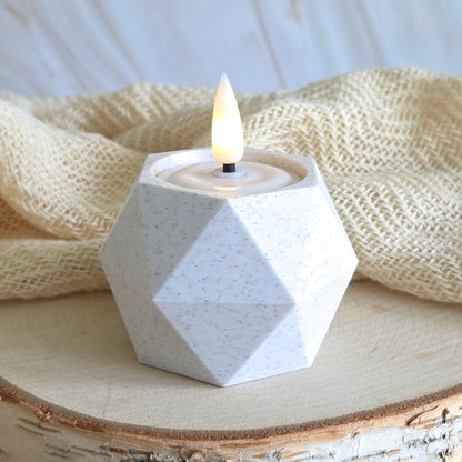 GEOMETRIC Lysestage i marmorlook med LED fyrfadslys – placeret med tekstil og lys træ