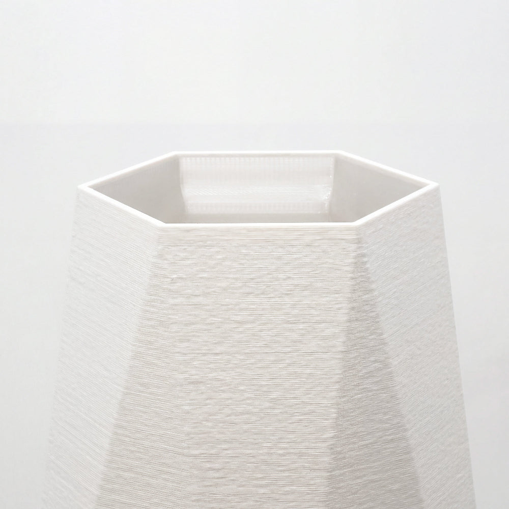 Nærbillede af åbning og facetter på hvid geometrisk vase