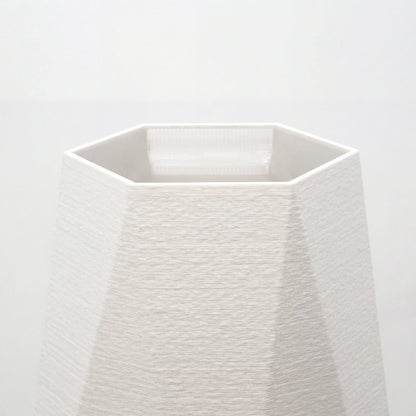 Nærbillede af åbning og facetter på hvid geometrisk vase