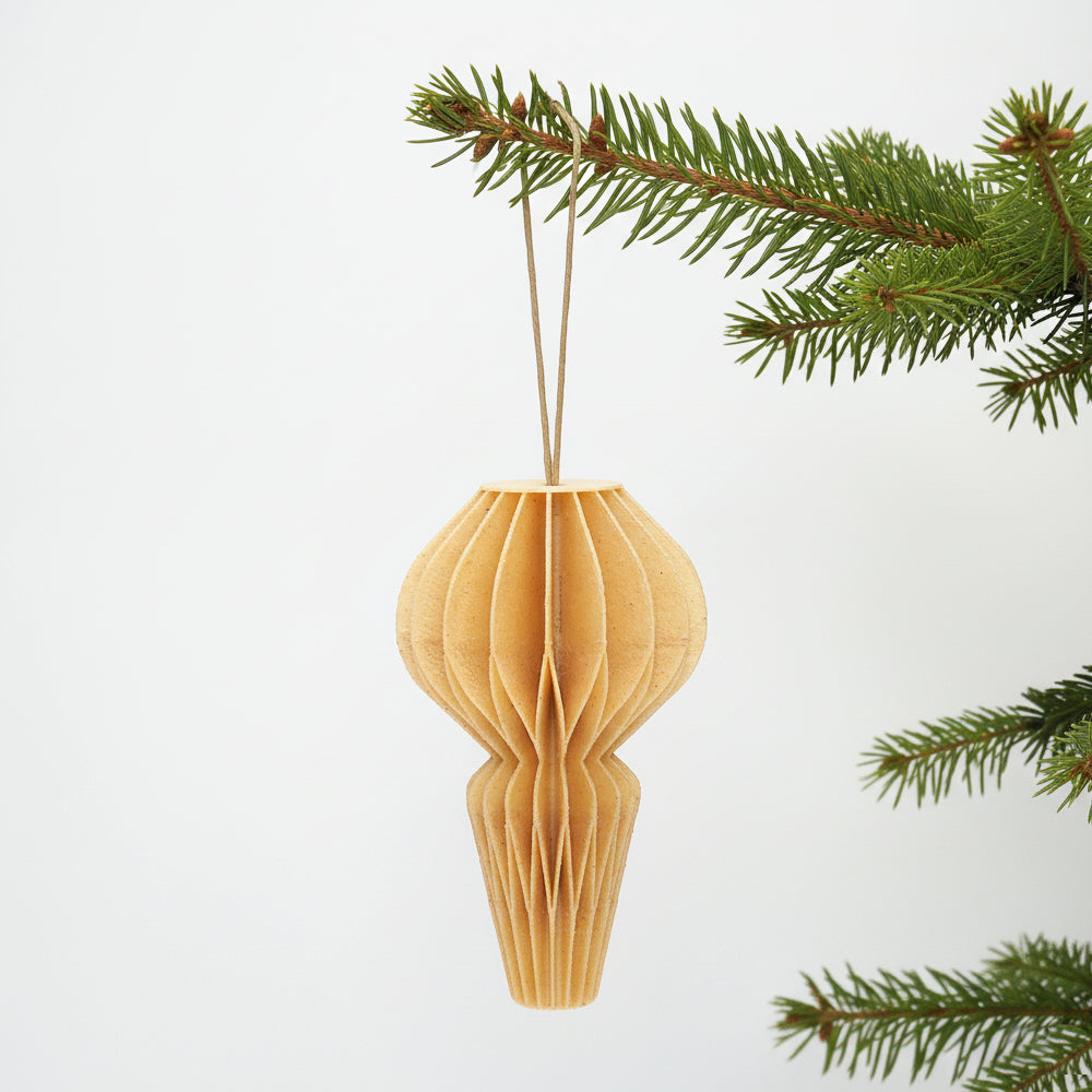 Birk farve honeycomb julepynt på en grøn gren – enkel og varm dekoration til juletræ eller vintergrene.