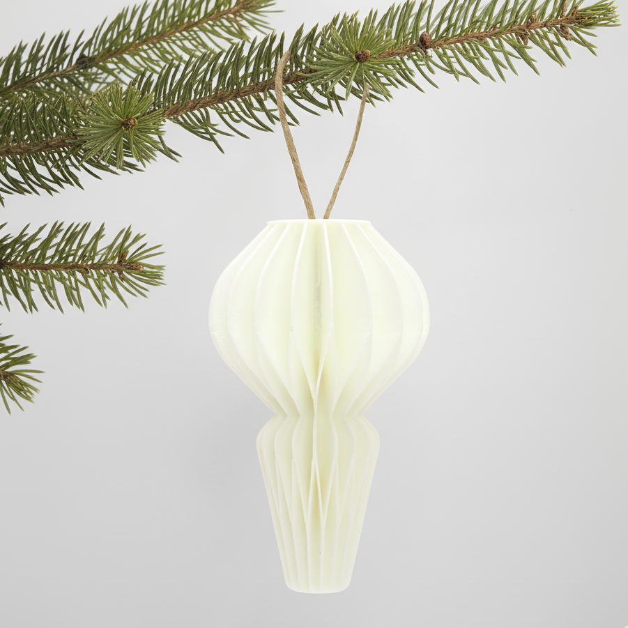 Hvid honeycomb julepynt på en grøn gren – enkel og varm dekoration til juletræ eller vintergrene.