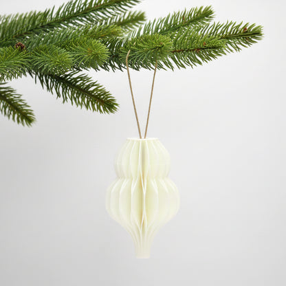 Hvid honeycomb dråbe som julepynt på en grøn gren – enkel og varm dekoration til juletræ eller vintergrene.