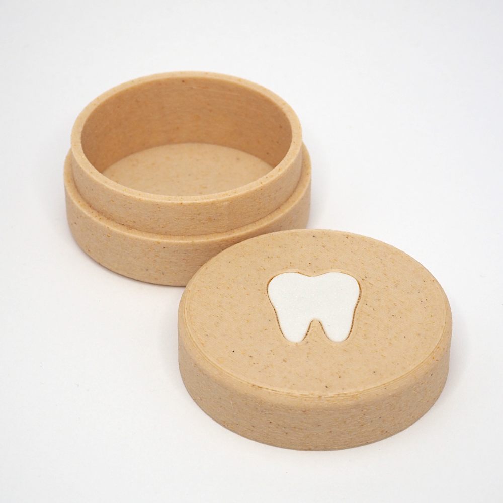 Lille tandfe æske til mælketænder med aftageligt låg, vist åbent med tandmotiv på låget ved siden af