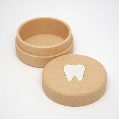 Lille tandfe æske til mælketænder med aftageligt låg, vist åbent med tandmotiv på låget ved siden af
