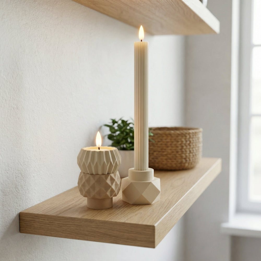 Stakket MODUL design lysestage i neutrale farver med tændt LED-kronelys, vist som rolig og moderne julepynt i hjemmet.