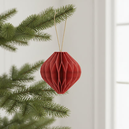 Rød honeycomb kugle som julepynt hængende på en gren – tidløs juledekoration til juletræ eller gren.