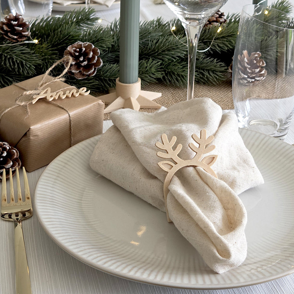 Birk farvet rensdyr servietring brugt som juleservietring på dækket tallerken med stofserviet