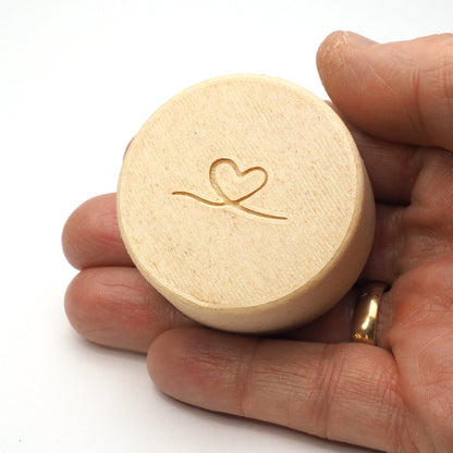 Bagsiden af lille tandfe æske til mælketænder, vist i en hånd for at illustrere størrelse