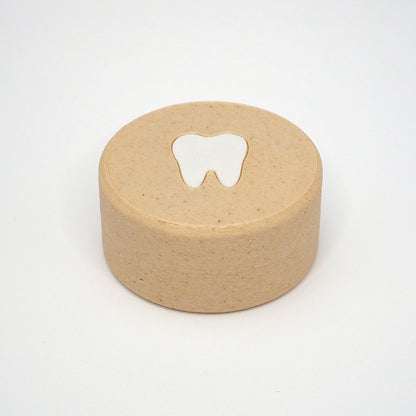 Packshot af lille tandfe æske til mælketænder, set forfra med låg og tandmotiv på toppen