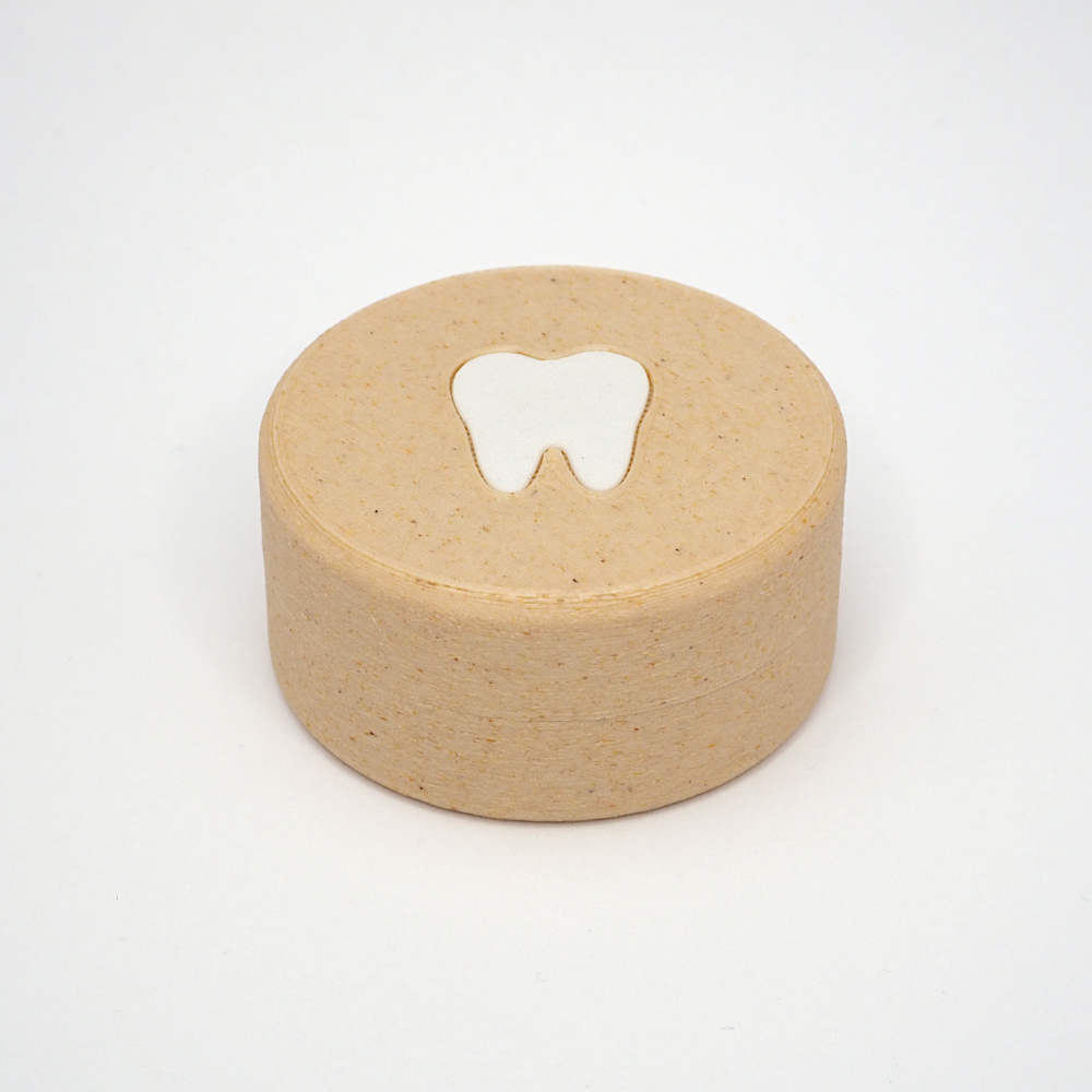 Packshot af lille tandfe æske til mælketænder, set forfra med låg og tandmotiv på toppen