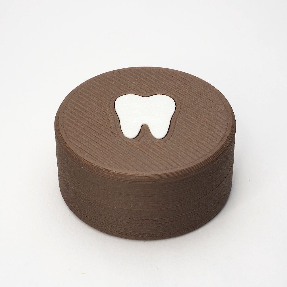 Packshot af lille tandfe æske i valnød til mælketænder, set forfra med låg og tandmotiv på toppen
