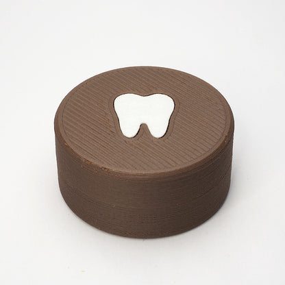 Packshot af lille tandfe æske i valnød til mælketænder, set forfra med låg og tandmotiv på toppen