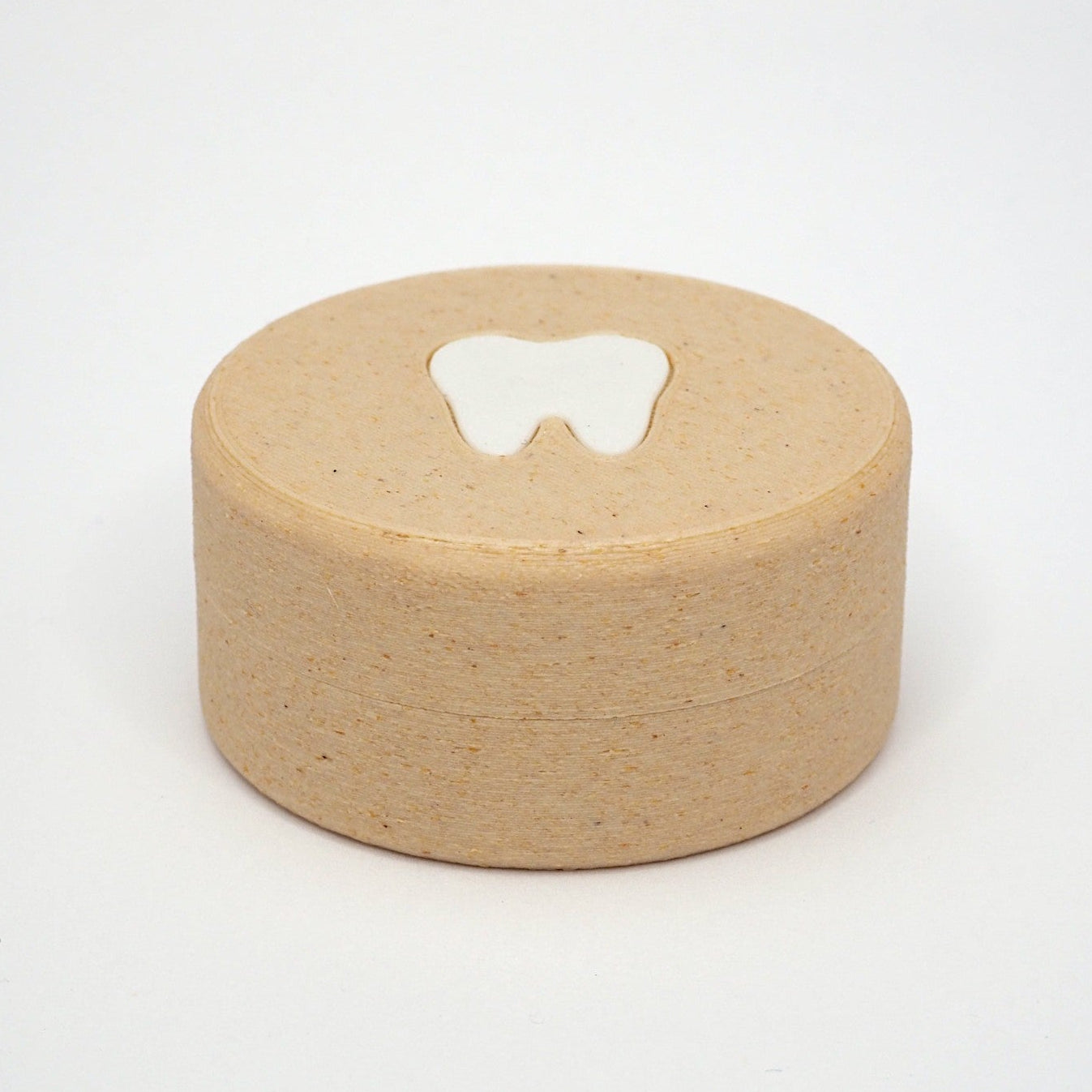 Packshot af lille tandfe æske til mælketænder, set forfra med låg og tandmotiv på toppen